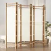 A multi-panel room divider made of bamboo and canvas, set up in a room with a plant and a bench in the background. Podgląd zdjęcia produktu