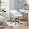 A white office chair is placed on a rug in a room with a desk and a bed. Produktbild-Vorschau