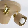 A close-up view of a beige and gold ceiling lamp with two adjustable spotlights. Produktbild-Vorschau