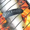 A close-up view of a Jim Beam branded fish grill basket with a graphic of a salmon and flames in the background. Produktbild-Vorschau