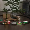 A Christmas train set with Santa Claus is displayed around a small Christmas tree with gifts underneath. Podgląd zdjęcia produktu