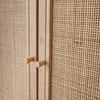 A close-up view of a wooden cabinet with rattan weaving and two wooden knobs. Produktbild-Vorschau