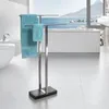 A modern bathroom with a large window overlooking the sea, featuring a sleek towel rack with blue towels. Produktbild-Vorschau