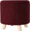 A burgundy round ottoman with wooden legs on a white background. Podgląd zdjęcia produktu