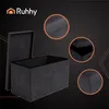 A dark, stylized background with geometric lines frames a gray storage bench with its lid open. Three circular insets highlight details of the bench's construction. Voir les images du produit