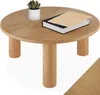 A round wooden coffee table with a plant and a book on it, set against a white background. Náhled obrázku produktu