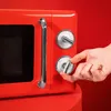A hand is shown adjusting the dial on a red retro-style microwave. Anteprima dell’immagine prodotto