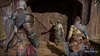Three characters are standing in a wooden interior, with one character in the center gesturing towards the other two. Produktbild-Vorschau