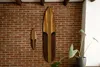 Two wooden surfboards are displayed on a brick wall, with a plant in the foreground. Produktbild-Vorschau
