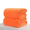 Two folded orange blankets are stacked on top of each other on a white surface. Produktbild-Vorschau