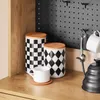 Kitchen counter with storage canisters, a mug, and a kettle. Produktbild-Vorschau