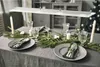 A dining table is set for a festive meal with a Christmas tree in the background. Produktbild-Vorschau