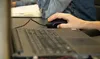 A person's hand is using a black gaming mouse connected to a laptop. Anteprima dell’immagine prodotto