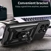 A black phone case with a ring stand is displayed on a wooden surface, with a laptop and headphones in the background. Produktbild-Vorschau