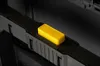 A close-up shot of a yellow button labeled 'PUSH' on a black modular toolbox. Voir les images du produit