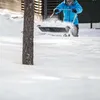 A person is shoveling snow with a snow shovel. Produktbild-Vorschau