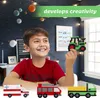 A young boy is smiling and holding a green tractor made of beads, with other bead vehicles in the foreground. The background is a dark blue wall with celestial decorations. Produktbild-Vorschau
