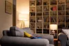 A cozy living room scene with a bookshelf, lamps, and a sofa. Produktbild-Vorschau