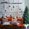 A festive Christmas dining table setting with a decorated tree and hanging ornaments. Produktbild-Vorschau