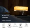 A bedside table with a lamp that resembles a tree, featuring a wood-like lampshade and a metallic base. Produktbild-Vorschau