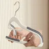 Hands demonstrating how to use a white and gray adjustable hanger. Voir les images du produit