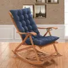 A blue cushion on a wooden rocking chair, placed indoors on a wooden floor with framed pictures on the wall in the background. Produktbild-Vorschau
