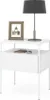 A white nightstand with a lamp, a framed picture, and a notebook on it. Náhled obrázku produktu