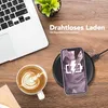 A desk scene with a laptop, coffee, and a smartphone charging wirelessly. Produktbild-Vorschau
