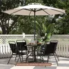 A patio set with a table, chairs, and an umbrella on a checkered patio. Podgląd zdjęcia produktu