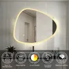 A modern bathroom vanity with a large, illuminated, irregularly shaped mirror above it. The bottom of the image displays icons representing product features. Produktbild-Vorschau