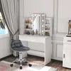 A vanity table with a lighted mirror and a chair in a room. Produktbild-Vorschau