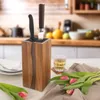 A kitchen counter scene with a knife block, a glass of amber liquid, and tulips. Náhled obrázku produktu