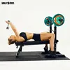 A woman is performing a dumbbell exercise on a bench press. Produktbild-Vorschau