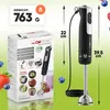 A Clatronic hand blender is shown next to its packaging, with fruit and a smoothie in the background. Voir les images du produit