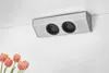 A silver electrical outlet strip with two sockets mounted on a white wall, with tulips in the foreground. Voir les images du produit