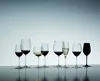 A collection of various wine glasses filled with different colored liquids, arranged on a reflective surface against a gradient background. Podgląd zdjęcia produktu