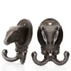 Two cast iron hooks shaped like sheep heads, displayed against a white background. Produktbild-Vorschau