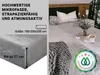 A bed with a fitted sheet, pillows, and a blanket, with text overlays describing the product features. Produktbild-Vorschau
