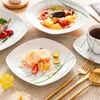 A table setting with plates of food, a cup of tea, and cutlery. Náhled obrázku produktu