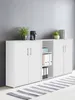 A white cabinet unit with multiple doors and shelves, decorated with plants and books, placed against a gray wall. Produktbild-Vorschau