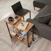 A laptop, coffee cup, book, and glass of water are on a wooden side table next to a sofa. Voir les images du produit
