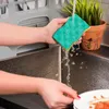 A person is rinsing a green and yellow sponge under running water in a kitchen sink. Anteprima dell’immagine prodotto