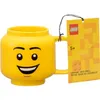 A yellow LEGO mug shaped like a LEGO minifigure head with a tag attached. Produktbild-Vorschau