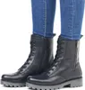 A pair of black leather lace-up boots worn by a person in blue jeans, shown against a white background. Produktbild-Vorschau