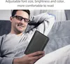 A man is relaxing on a couch while holding and looking at an e-reader. Podgląd zdjęcia produktu