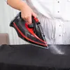 A person ironing a black garment with a steam iron. Náhľad obrázku produktu