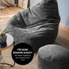 A large grey corduroy beanbag chair and a matching pouf are shown in a living room setting. Anteprima dell’immagine prodotto