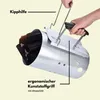 A person is holding a charcoal chimney starter filled with burning charcoal. Produktbild-Vorschau