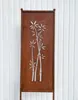 A decorative metal screen with a bamboo motif, likely for garden use, set against a white paneled background. Produktbild-Vorschau