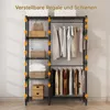 A black metal shelving unit with clothes hanging on one side and storage baskets and boxes on the other, against a white wall. Voir les images du produit